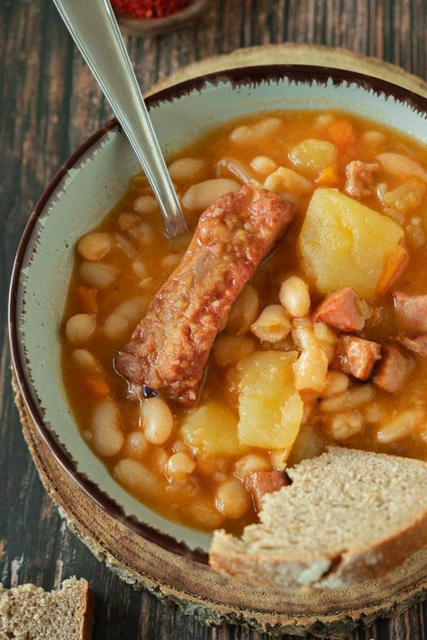 A bowl full of grah stew with white beans, potatoes, carrots, and smoked pork ribs. Dutch Oven Dinners, Dutch Oven Corned Beef, Mediterranean Beef Stew, Healthy Bacon Recipes, Smoked Pork Roast, Oven Dinners, Pot Roast Sandwiches, Homemade French Onion Soup, Beans Potatoes