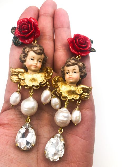 Shipping with DHL Baroque earrings with cherubs, red roses and crystal drop For lovers of Sicilian Baroque these earrings are a real must have From the passion for Sicily and the Baroque taste are born these eccentric pendant earrings with cherubs, river pearls and crystal drops When I make earrings one of my first priorities is their weight. I love big earrings but I try to do everything to make them light and wearable. Angels are a real treat. They are made of wood, carved and painted by hand Culture Pearl Earrings, Red Rose Earrings, Baroque Earrings, Ethereal Jewelry, Earrings Display, River Pearls, Feather Jewelry, Funky Jewelry, Earrings Pearl