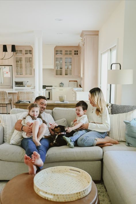 Family playing on the sofa in the living room, father, mother, daughter, son and a black dog In Home Lifestyle Session Family Outfits, Inside Home Photoshoot Ideas, Family Photoshoot House, Family Home Shoot, New Home Photoshoot Family, I’m Home Family Photos, Family Pictures In Home, Living Room Family Photoshoot, In Home Lifestyle Session Family