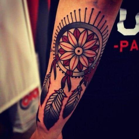 This tattoo perfectly combines elements of a traditional dreamcatcher and elements from Native American design elements. It uses thick lines with the generous use of bold colors and is the perfect accessory if you love to wear colorful dresses. #tattoofriday #tattoos #tattooart #tattoodesign #tattooidea Traditional Dream Catcher Tattoo, 07 Tattoo, Elbow Tats, Positive Tattoos, Dreamcatcher Tattoos, Mandala Dreamcatcher, Tattoo Feather, Dream Catcher Tattoo Design, Dream Catcher Tattoo