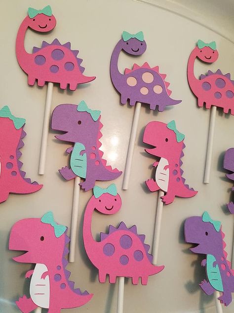 It is very important that you leave your party date in the note section when checking out. Thank you! All sales final! No cancellations accepted. Before you purchase make sure our processing time and shipping times will coincide with your party date. If you are unsure message me first before placing your order. Thank you! These dinosaurs are adorable! You will receive 1 dozen of these girly dinosaur cupcake toppers How fun it will be to have these on your party tables. Each dinosaur is made out Purple Dinosaur Birthday Party, Girly Dinosaur Birthday Cake, Pink And Purple Dinosaur Party, Girly Dinosaur Party, Princess Dinosaur, Pink Dinosaur Party, Girly Dinosaur, Dinosaur Cupcake, Combined Birthday Parties