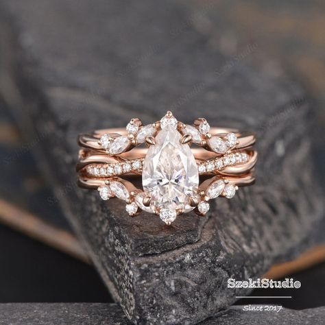 "Pear Moissanite Ring Set Rose Gold Infinity Engagement Ring Twist  Moissanite Band Cage Ring Enhancer Diamond Half Eternity Bridal Ring 2pcs Different main stone sets of the same model: https://www.etsy.com/listing/1504785119 ITEM INFORMATION Metal Type - Solid 14k Rose Gold, yellow gold, white gold  Band Width - (approx. 2.3mm) Center Stone - from 6*9mm ,Moissanite, Pear Cut  Clarity - VVS Color -  D-E-F Side Stone: moissanite Weight - 0.4ct Total Interested in a bridal set: https://www.etsy.com/listing/981252911 https://www.etsy.com/listing/651183149 https://www.etsy.com/listing/916561718 Same design with different gemstones: https://www.etsy.com/listing/609590330 https://www.etsy.com/listing/655314606 https://www.etsy.com/listing/654797976 Please select the side stones type in the drop Pear Ring Enhancer, Cage Ring, Infinity Engagement Ring, Makeup Images, Enhancer Wedding Band, Moissanite Ring Set, Engagement Rings Twisted, Ring Enhancer, Moissanite Band