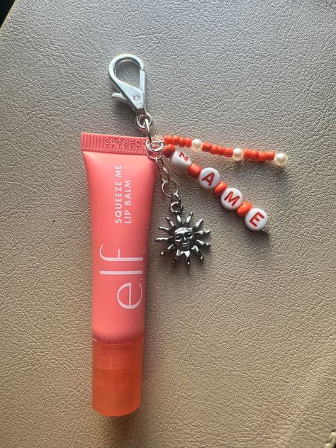 Join in on the cute and trendy lip balm keychain! This product is reusable and can be customized personally to you.  1. Choose which flavor lip balm you would like, or opt out and choose "keychain only" if you have your own lip balm you want to add it to.  2. Choose the pendant you would like. (More to come soon!)      - Sun       - Moon       - Cactus       - Balloon Dog       - Sport ( Softball, Baseball, Tennis, Football, Basketball, Soccer, and Volleyball, with corresponding colors) 3. Include your name for the keychain. Cute Diy Crafts For Best Friends, Chapstick Keychain Diy, Lip Balm Keychain Aesthetic, Home Made Keychain Ideas, Lip Gloss Keychain Ideas, Cute Gifts To Make For Your Best Friend, Lip Balm Charm Keychain, Charm Crafts Diy Projects, Lipgloss Keychain Ideas