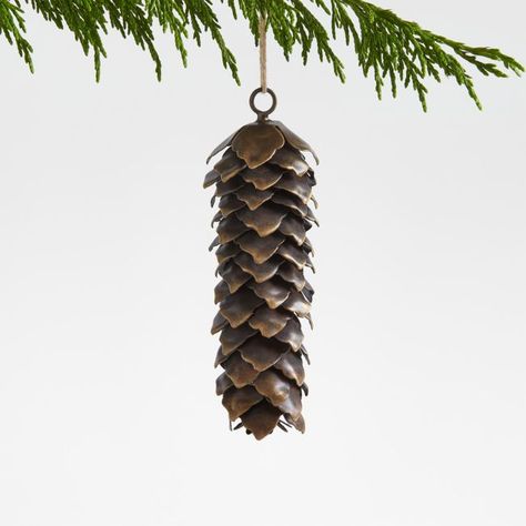 Our pinecone ornament adorns your tree with organic beauty. Small pieces of iron are bent by hand to create the naturalistic look of the pinecone's scales. Skilled craftspeople complete the ornament with a burnished bronze finish that gleams subtly among the string lights. Our exclusive pinecone Christmas tree ornament makes a lovely gift topper for the nature lover.   • Hand-bent and -finished  • Iron with burnished bronze finish  • Jute twine  • Wipe clean with soft, damp cloth  • Made in Indi Metal Pinecone, Metallic Christmas Decor, Pinecone Christmas Tree, Pinecone Christmas, Christmas Tree Decorating Themes, Metallic Christmas, Classic Christmas Tree, Pinecone Ornaments, Crate Barrel