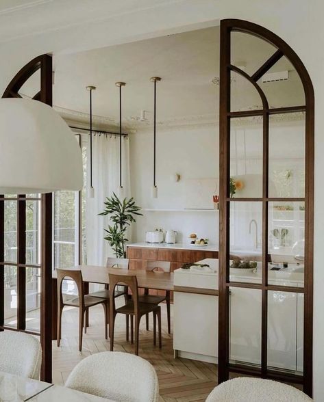 Vivir Design | Whether it’s a partition or a full wall…interior glass room dividers are a fantastic way to preserve sight lines, keep that natural light… | Instagram Glass Partition Designs, Parisian Kitchen, Concrete Countertops White, Glass Room Divider, Concrete Countertops Kitchen, Transitional Decor Kitchen, Glass Room, Living Room Partition, Arched Doors