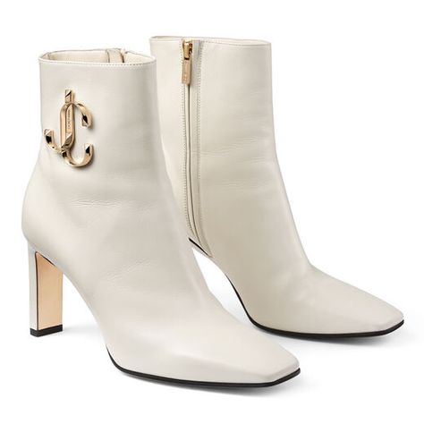 Jimmy Choo MINORI 85   Minori 85 in latte calf leather offer unparalleled elegance. Designed with a sleek, slightly squared off toe and our intertwined JC logo, these elegant booties pack a powerful punch. Pair Minori with tailoring or denim to exude confidence wherever the day takes you.  Calf leather Ankle boot Square toe Gold-tone embossed JC logo Leather lined Leather sole Heel height measures: 65mm/2.6 inches Made in Italy  #italianshoe #fashion #jimmychoo #italianleather #white #wedding #w Fancy Boots, White Leather Booties, Shoe Goals, Jimmy Choo Boots, Afghan Fashion, Funky Shoes, Design Shoes, Shoes Luxury, Beige Shoes