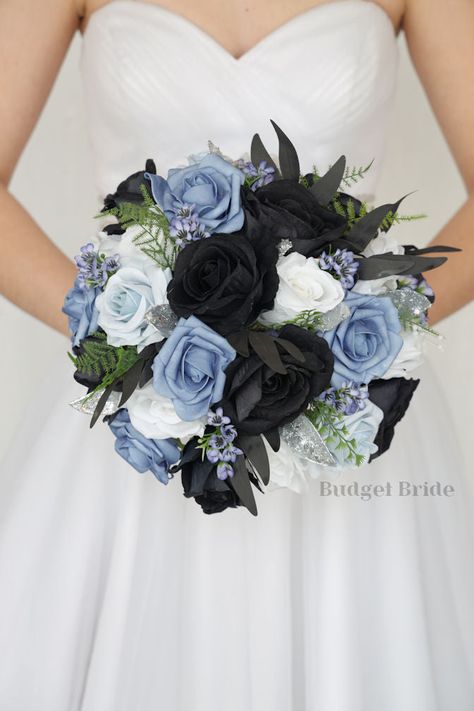 This magnificent rounded brides’ bouquet is crafted using black, dusty blue, steel blue and light blue roses of the highest quality. This elegant bouquet is sure to leave a lasting impression. The delicate silver accents in this collection, create a bright and dazzling arrangement that is sure to turn heads. With a mixture of black foliage and greenery this bouquet is sure to make a statement. All of our bouquets are a wonderful option for destination weddings, as they can be bought in advance a Blue Black And White Bouquet, Royal Blue And Black Bouquet, Midnight Blue Themed Wedding, Powder Blue And Black Wedding, Slate Blue And Black Wedding, Periwinkle And Black Wedding, Black And Dusty Blue Wedding Theme, Black And Blue Wedding Bouquet, Blue And Black Flowers Bouquet