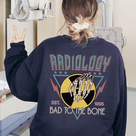 🩻(DESIGN PRINTED ON BACK) Show your support for the important work of Radiology professionals with this fun sweatshirt! Find unique Radiology apparel and gifts here in our shop. THIS DESIGN IS PRINTED ON THE BACK AND FEATURES WEATHERED/DISTRESSED DETAILS AND PRINTED ON FRONT AND BACK. FINAL PRINT COLORS MAY APPEAR SLIGHTLY DIFFERENT FROM PHOTOS VIEWED ON COMPUTER MONITORS AND CELL PHONE SCREENS. ⚡ Printed on the most popular Unisex Sweatshirt, the Gildan 18000 is 50% Cotton / 50% Poly. The soft fleece lining makes it super Comfy and is sure to become your new favorite! ⚡ This Unisex Sweatshirt fits like a Men's on Women, but is not overly large. ⚡ This Sweatshirt is printed with high quality, non-toxic Direct To Garment Digital Inks for beautiful and natural results! ⚡ WASHING INSTRUCTION X Ray Tech Tattoo, Radiology Apparel, Rad Tech Week, Radiology Shirts, Radiologic Technologist, Radiology Student, X Ray Tech, Radiology Technologist, Tech Week