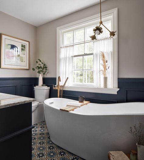 Traditional bathroom renovation with colorful floral tile, navy wainscoting, large soaker tub, small floral chandelier with vintage details Grassroots Design, Chandelier Over Bathtub, Bathroom Chandelier, Slanted Ceiling, Sazerac, Floral Chandelier, Modern Lighting Design, White Chandelier, Chandelier Bedroom