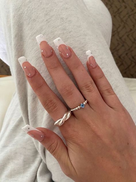 White Nails With Rhinestones French Tips, White French Tip Nails With Crystals, White French Tip W Pearls, Nail Inspo White Tip, White French Tip Nails With Rhinestones On Ring Finger, White Decorated Nails, White With Diamonds Acrylic Nails, Square French Tip With Diamonds, Custom French Tip Nails