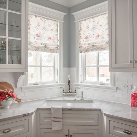 Corner windows can be a challenge for many reasons.  In this kitchen we went with a simple yet classic design which highlighted the pretty molding detail.  Roman shades were the perfect solution to provide privacy at night while letting lots of light in during the day.   Imagine doing dishes here!  #romanshades #transitionalkitchens Kitchen Corner Window Treatments, Kitchen Design With Corner Window, Kitchen Corner Windows Over Sink, Corner Kitchen Sink With Windows, Corner Windows In Kitchen, Corner Sink In Kitchen, Kitchen Sink Corner, Small Kitchen Corner Sink, Kitchen With Sink In Corner Layout