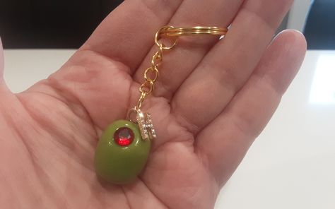 Personalized Handmade Martini Olive Keychains. Choose your size of Olive and whether you would like a red clay or faux gemstone center. Enter initial choice in Personalization Box. These olives are handcrafted by yours truly💝  Large size olive with fake gemstone is pictured on keychain. Once I have attached initial, it can't be removed. Message me with any special requests. Are you looking for the assortment of olives? They Are Here:  https://www.etsy.com/ca/listing/1337501454/handmade-miniature-olivesgreen-olives?click_key=f39b3a178403a6c33356d70306af87fa3054373d%3A1337501454&click_sum=46bcaca6&ref=shop_home_active_1&crt=1&sts=1 As they are handmade, each olive may differ from the next. (Color may differ from monitor to monitor and from each batch of color I mix ) Shipping Within Canada Unique Key Chain, Trendy Gifts For Women, Fun Keychains, Gifts For Mother In Law, Cool Keychain, Keychain Collection, Martini Olive, Martini Olives, Men's Gifts