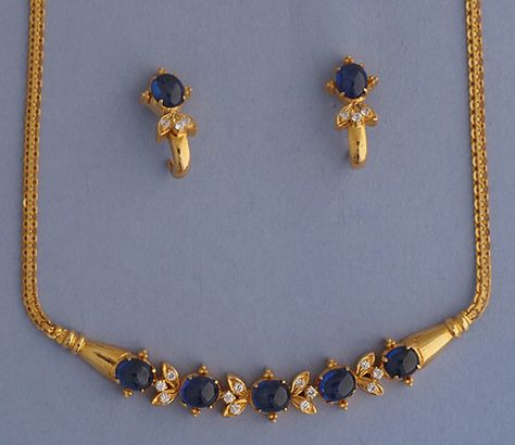 Diamond & Blue Sapphire set This 21k Gold necklace & earrings set is ahead of its time. Length of the necklace is 16 inches. The set is studded with Total Weight of diamonds is 0.55 carats & 15 carats of blue sapphires. The J shaped earrings curve below the ear. #21k, #21k Gold, #21k Gold set, #diamond, #blue sapphire, #necklace, #earrings, #tops, #diamond tops, #bismarck, #chain, Tops Diamond, Diamond Tops, Gold Jewelry Simple Necklace, Beautiful Gold Necklaces, Gold Necklace Indian Bridal Jewelry, Gold Jewelry Stores, Gold Pendant Jewelry, Wedding Jewellery Collection, Black Beaded Jewelry