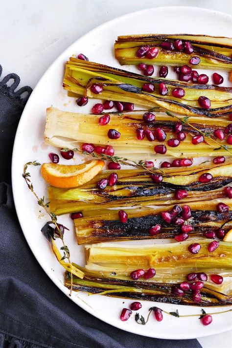 Caramelized leeks are melt-in-your-mouth delicious! This easy recipe for braised leeks is made in a skillet. The leeks are cooked in butter, broth, orange slices, and thyme, then topped with an orange, ginger, and pomegranate relish before serving. It's a delicious vegetarian side! Leek Appetizer Recipes, Hobbit Luncheon, Leeks Recipes, Caramelized Leeks, Roasted Kohlrabi, Easy Vegetable Side Dish, Roasted Leeks, Braised Leeks, Easy Holiday Side Dishes