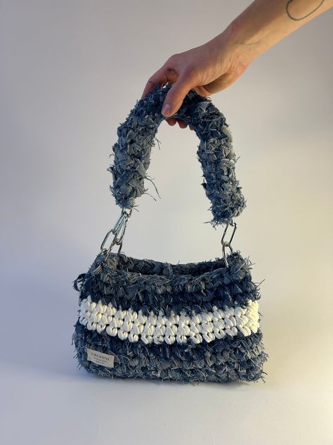 Up-cycled denim crochet bag in size M in light denim with white detailing. Sustainably handmade from up-cycled denim and 100% recycled yarn. Size: Length: 17 cm Width: 11 cm Height﻿: 15 cm Denim Yarn Projects, Denim Yarn Crochet, Crochet Bags With T Shirt Yarn, Yarn Bags Crochet, Crochet Jeans Bag, Denim Crochet Bag, Crochet On Denim, Crochet Repurpose, Crochet Bag Accessories