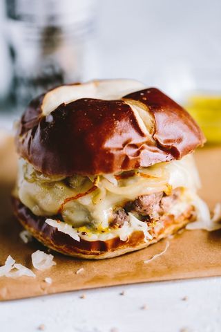 Bratwurst Burger w/ Beer Braised Onions & Sauerkraut | Beyond The Bayou | Bloglovin’ Braised Onions, Munster Cheese, Sausage Burgers, Bratwurst Sausage, Cajun Cooking, The Bayou, Burger Recipe, Good Burger, Burger Recipes