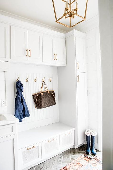 Mudroom built-in bench with lattice front drawer fronts and brass pulls compliment brass hooks on beadboard trim between tall cabinets. Beadboard Trim, Front Hall Closet, Modern Cabin Interior, Transitional Laundry Room, Entry Cabinet, Tall Cabinets, Built In Lockers, Mudroom Cabinets, Mudroom Laundry