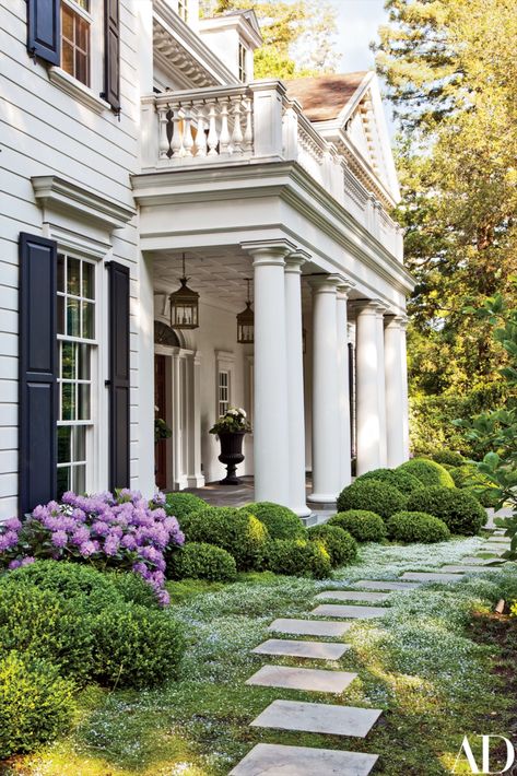 DESIGN | NgLp Designs shares AD | Architectural Disgest — "Boxwood and rhododendrons soften the columned entrance on the grounds of a California residence created by Charlie Barnett Associates" | Elizabeth Everdell Garden Design, landscaping." | architecture, colonial home, formal garden, garden design, summer, outdoor living, beautiful luxury home design /// #gardendesign #colonialhome #entrance Colonial Landscaping, Column Ideas, Exterior Landscaping, Porch Styles, Front Landscaping, Casas Coloniales, Colonial Revival, Luxury House Designs, House Landscape