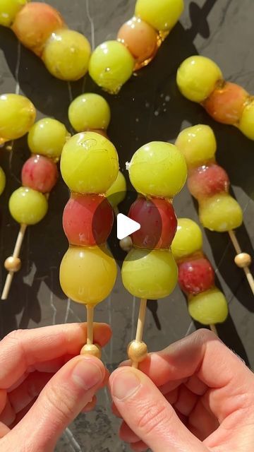 Ma’ayan Moss on Instagram: "2 ingredient grape tanghulu // full recipe ↓   These crunchy Chinese snacks come together in just a few minutes using only ✨TWO✨ ingredients! Trust us, this is going to blow your mind 🤯  INGREDIENTS: 40-50 grapes (we used both green and red) 1 cup water  2 cups sugar  INSTRUCTIONS:  Start by washing the grapes thoroughly and patting them completely dry. Thread 3 grapes onto each bamboo skewer.   In a small pot, combine water and sugar, and bring it to a boil. To test if the syrup is ready, take a small spoonful and drop it into a cup of ice-cold water. If it hardens instantly, the syrup is perfect. Remove from heat.  Set up a bowl of ice water. Dip each grape skewer into the syrup, coating all the grapes evenly, then immediately dip it into the ice water to set Grape Kabobs, Grape Tanghulu, Tanghulu Recipe, Grape Snacks, Chinese Snacks, Fruit Skewers, Fruit Cups, Bamboo Skewers, Ice Water