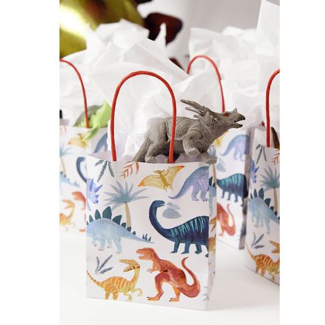 Send your party guests home roaring with happiness from your dinosaur baby shower with these terrific Dinosaur Kingdom Favor Bags! These paper party bags feature a beige background with colorful dinosaur illustrations with copper & green foil detail and a charming twisted paper handle. Fill them up with dinosaur temporary tattoos and tasty treats and friends and family will leave your little one's Three-Rex dinosaur birthday party with smiles on their faces! Item Details: * Pack of 8 party b Meri Meri Dinosaur, Dinosaur Balloon Garland, Dino Girl Party, Dinosaur Favor Bags, Dinosaur Party Decor, Birthday Party Dinosaur, Dinosaur Favors, Vintage Dinosaur, Party Dinosaur