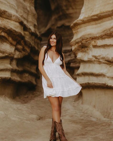 White Dresses Country, White Flowy Dress With Cowgirl Boots, White Dress With Brown Cowboy Boots, Sun Dress With Cowgirl Boots, Senior Pics Cowboy Boots, Cowgirl Boot Senior Pictures, White Dress Cowgirl Boots Senior Pictures, Flowy Dress With Cowboy Boots, Poses With Cowboy Boots