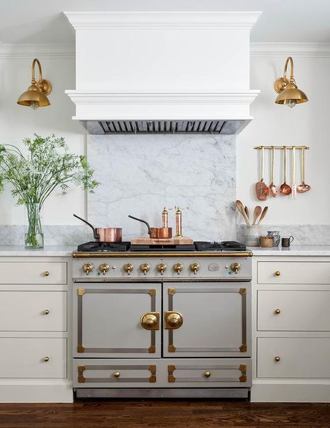 Cottage kitchen features a light gray La Cornue Cornufe range with brass hardware, a gray marble slab backsplash and ivory cabinets. Concrete And Wood Kitchen, White Kitchen Peninsula, Marble Slab Backsplash, La Cornue Chateau, La Cornue Kitchen, Black Kitchen Shelves, Cornue Range, French Stove, Beadboard Trim