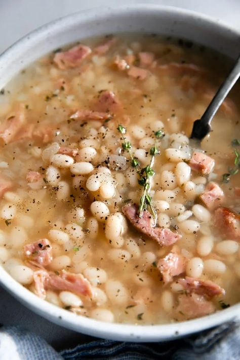 This Navy Bean Soup with Ham is a simple, hearty, and flavorful bean soup recipe filled with leftover ham and tender cooked navy beans. Perfect for lunch or dinner with a side of buttery bread. Ham Navy Bean Soup Crockpot, Senate Navy Bean Soup Recipe, Creamy Navy Bean Soup, Navy Bean Soup With Ham Crockpot, Ham N Bean Soup, Mayo Coba Beans Recipes, Ham And Navy Bean Soup Recipes, Ham And Bean Soup Stovetop, Crockpot Navy Bean And Ham Soup