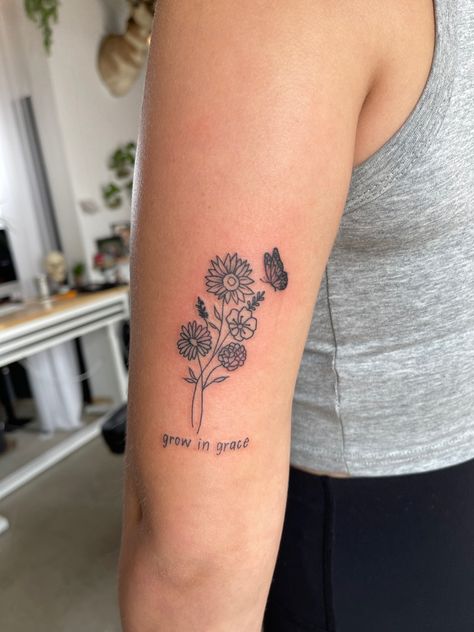 Back Of Arm Tattoo Meaningful, Flower Tattoos Behind Elbow, Women’s Flower Arm Tattoo, Simple Flower Tattoo Back Of Arm, Grace Flower Tattoo, Tattoo Ideas Female Above Elbow, Bloom And Grow Tattoo, Grandma Flower Tattoo, Flower Bouquet Tattoo With Words