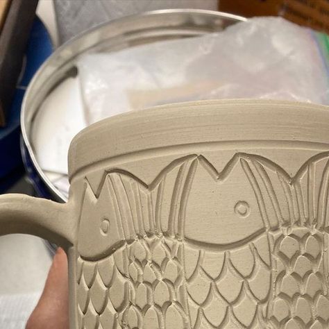 Pamela Johnson-Howe on Instagram: "Still working on a custom order for 12 gargantuan mugs, 6 tessellating fish, 6 sgraffito walleye, northern pike, and musky. The photos don’t show just how big they are. Hopefully bisque firing these and more tomorrow. #herefishyfishy #fish#fishtessellations #mugshot#bigmugs#pottery#carvedclay#potterslife#pottersofinstagram #wisconsinartist#chicagoartist #handmade#upnorth#northwoods#northwoodsart #oneofakind#oneatatime#lakelife #vilascounty #functionalpottery #f Sgraffito Fish Designs, Ceramic Fish Mug, Fish Mug Ceramics, Cat Pottery Mug, Mug Carving Ideas, Sgraffito Mug, Sgraffito Fish, Sgraffito Designs, Fun Objects