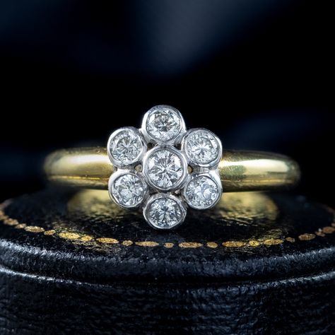 Showcasing a beautiful Edwardian inspired daisy cluster ring adorned with seven brilliant cut diamonds bezel set in a white gold face. The stones are approx. 0.10ct each and have a bright clean sparkle with excellent SI1 clarity – H colour (approx. 0.70ct total). The thick, 18ct yellow gold band is lovely and smooth with Birmingham hallmarks and the maker’s initials within. It’s very eye catching and the diamonds glisten beautifully in the light. On sale now for 50% off, this piece is a cl... Stunning Diamond Rings, Edwardian Style, Gold Face, Edwardian Fashion, Bezel Diamond, Gold Band, Cluster Ring, Brilliant Cut Diamond, Bezel Setting