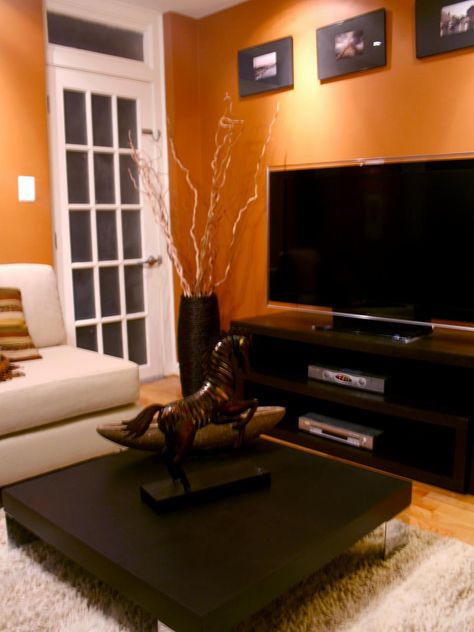 Black furniture and white trim provide contrast for this room's bold orange walls. Orange Living Room, Orange Rooms, Basement Living, Storage Inspiration, Living Room Orange, Living Room Color Schemes, Orange Walls, Design Apartment, Room Paint Colors