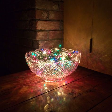 Quick party decoration! Recipe: (1) crystal punch bowl, add strand of multi-color lights, plug and enjoy.  *be mindful of lamp heat* Vintage Punch Bowl Ideas, Upcycle Punch Bowl, Punch Bowl Repurpose, Glass Bowl Decor Ideas Centerpieces Christmas Ornament, Punch Bowl Flower Arrangements, Punch Bowl Decorating Ideas, Crystal Bowl Decor Ideas, Repurposed Doors, Bulb Ideas