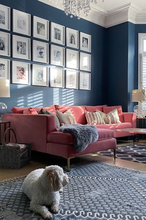 a navy living room with a pink sofa, some side tables, a grid gallery wall, printed rugs and a crystal chandelier and a cool lamp Blue And Pink Living Room, Pink Sofa Living Room, Navy Living Rooms, Vibrant Living Room, Apartments Decorating, Decorating Farmhouse, Pink Living Room, Pink Sofa, Kitchen Decorating