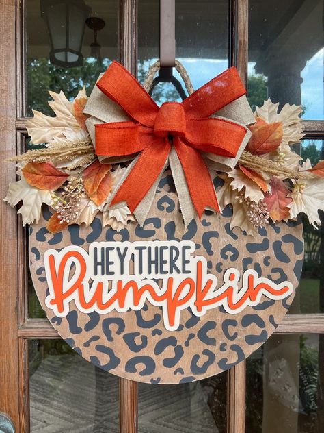 The adorable cheetah print door hanger is the perfect addition to your Fall decorations! The door sign measures 18 inches in diameter and is 1/2 inch thick. The 3D lettering is cut from 1/8 inch wood. The bow and leaves are attached with staples, and the sign is finished with a decorative rope for hanging.  Please messsage me with any questions or special requests. Thank you for visit my shop! Sunflower Round Door Hanger, Stitch Door Hanger, Checkered Door Hanger, Wooden Fall Door Hangers, Fall Wood Door Hangers, Fall Door Hanger Ideas, Diy Halloween Door Hanger, Fall Door Hangers Wooden, Diy Wood Door Hanger