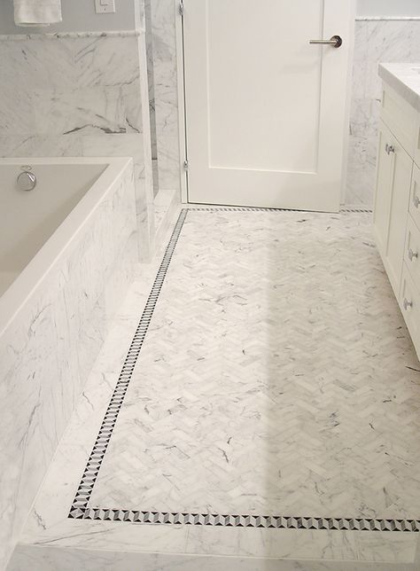 Tribeca Residence - Master Bathroom.  Walls & Tub Surround: Carrara Claro 8" x 16" Honed.  Floor: Center Rug Custom Mosaic - Carrara Claro Herringbone, 1 1/8" x 3 3/8" with Tight Joints.  Floor: Decorative Border Custom Mosaic - Carrara Claro, Bardiglio & Nero 1-1/2" Madison Border. Carrara Bathroom, Kids Bathroom Sign, Center Rugs, Marble Bathroom Floor, White Marble Bathrooms, Bathroom Walls, Tile Rug, Tub Surround, Marble Vanity