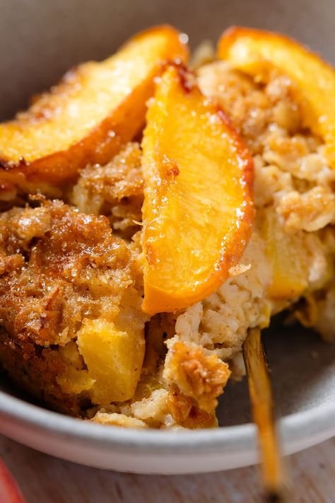 This Baked Peach Oatmeal is packed with flavor and really easy to make. The oatmeal is light and packed with chopped peaches on the inside and crispy and toasty on the top. It gets topped with more peach slices that caramelize with sugar in the oven and take it from great to amazing. Serve with yogurt, berries, or more peaches for breakfast or brunch. Peach Cobbler Yogurt Bowl, Peach Breakfast Ideas, Peaches For Breakfast, Breakfast Peach Recipes, Peach Breakfast Recipes Healthy, Peach Breakfast Recipes, Peach Oats, Peach Recipes Breakfast, Peach Baked Oatmeal