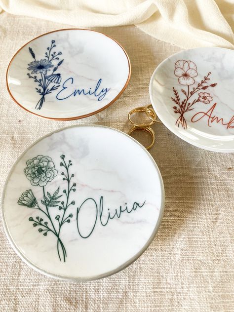 Personalized birth flower ring dishes are the perfect bridesmaid or best best friend gift. Our marble jewelry dishes are super high quality and will become an instant heirloom. Personalize your dish with name, flower/text color and your choice of gold, rose gold, silver, or plain edge. Each dish is kiln fired in our Pennsylvania studio. F E A T U R E S * Material: High Quality Kiln Fired Ceramic * Dimension: 4in. diameter * Rim Finish: Gold ∙ Rose Gold - Silver or Plain * Text and Flower: Terrac Bridesmaid Gifts From Bride, Flower Text, Marble Jewelry, Ring Dishes, Birth Month Flower, Bridesmaid Proposal Box, Month Flowers, Birth Month Flowers, Flower Plates