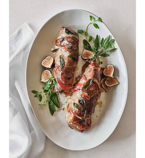 Prosciutto and Sage Wrapped Pork Tenderloin Recipe | Crate & Barrel Paleo Ham, Wrapped Pork Tenderloin, Pork Tenderloin Recipe, Modern Tables, Tenderloin Recipe, Ceramic Platter, Sliced Meat, White Dinnerware, Ceramic Platters