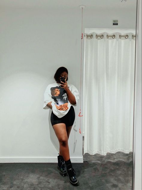 Black girl standing in front of mirror, posing in a white oversized space graphic kenzo t-shirt. Styled with black biker shorts and black dr martens boots. Biker Short And Graphic Tee Outfit, Oversized Shirt With Biker Shorts Outfit, Combat Boots And Shorts Outfit Black Women, Graphic Tee And Shorts Black Women, Biker Shorts And Combat Boots, Biker Shorts Boots Outfit, Dr Martens And Shorts Outfit, Boots With Shorts Outfit Summer, Shorts With Docs Outfits