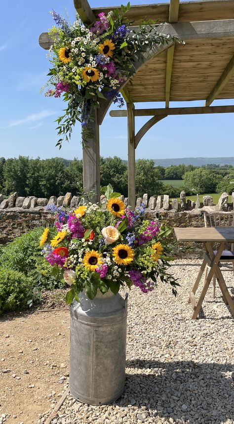 A perfect summer's day, with meadow style, colourful blooms decorating the arch. June Wedding Centerpieces Diy, Wildflower Decor Wedding, Colourful Outdoor Wedding, Wedding Barrier Ideas, Country Style Wedding Flowers, Meadow Themed Party, Summer Wild Flower Wedding, Wedding Arbor Wildflowers, Simple Wildflower Wedding Arch