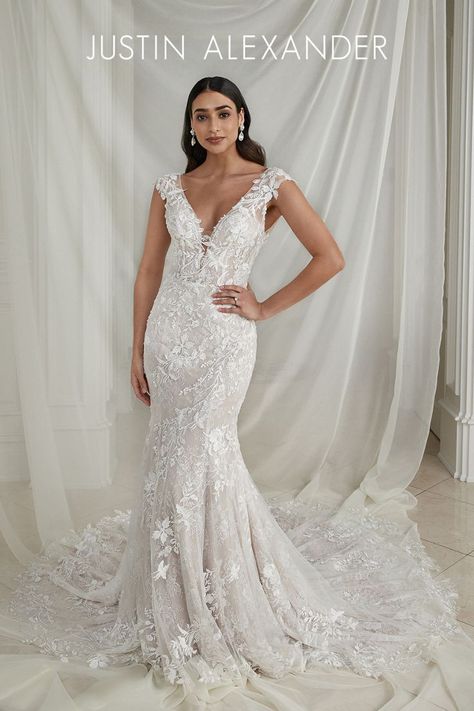 Intricately placed lace gives off the most romantic vibes with this fit and flare wedding dress. Featuring lovely feminine beaded appliqués, an allover Chantilly lace throughout the gown adds soft dimension. The sheer bodice is given a subtle plunge at the V-neckline that is perfectly accented with cap sleeves and a low scoop back. The fitted silhouette, paired with a stretchy jersey lining, will hug and contour your curves. Wedding Dress With Cap Sleeves, Justin Alexander Bridal, Justin Alexander Wedding Dress, Flare Wedding Dress, Sheath Wedding Dress Lace, Dress With Cap Sleeves, Bridal Elegance, Justin Alexander, Fit And Flare Wedding Dress