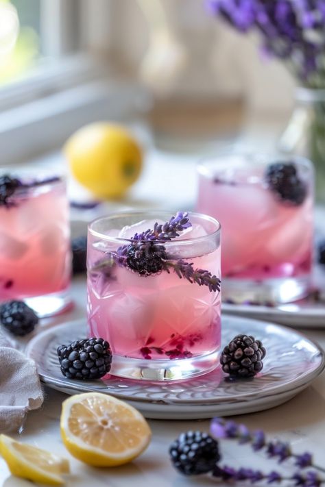 Three glasses of lavender and blackberry lemonade with ice placed on a table with fresh blackberries, lavender sprigs, and a cut lemon. Lavender Drinks, Lavender Lemonade Recipe, Lavender Drink, Blackberry Mojito, Blackberry Lavender, Blackberry Lemonade, Flavored Lemonade, Lemonade Punch, Cozy Weather