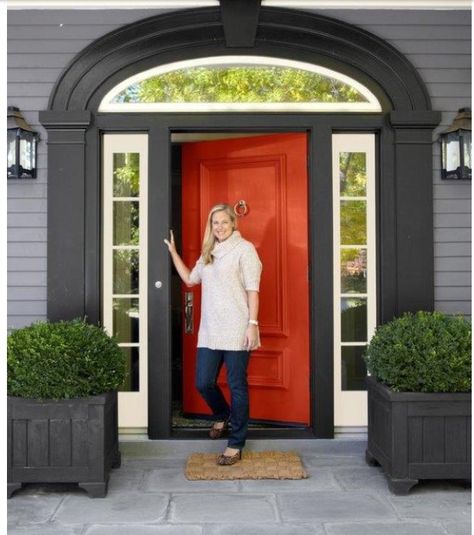 Grey siding with black trim, white accent and red/orange door, and large time walk way, cool lights and bushes. Orange Front Doors, Front Door Planters, Mixing Paint Colors, Door Planter, Red Front Door, Orange Door, Black Shutters, Grey Houses, Exterior Paint Colors For House