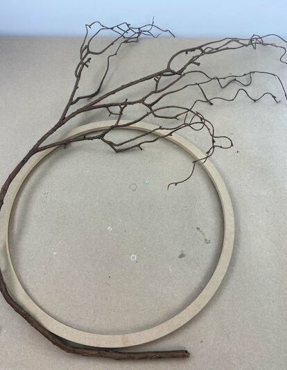 With my beautiful wisteria vine around the front door, I knew I would need a wreath to coordinate with it. I had to figure out have to make a wreath that mirrors the vine. Did you see the vine? You can see more of my crafts and creations  here. I found this narrow wooden ring at Michael’s. Taking a faux branch, bend it around the edge of the wooden wreath. To give a more natural look, use paper wrapped wire to secure the branch to the wreath.  Tuck a fe… Wisteria Wreath Diy, Wisteria Wreath, Plant Stand Diy, Vine Ideas, Umbrella Wreath, Wisteria Vine, Diy Dining Room Table, Make A Wreath, Wooden Wreath