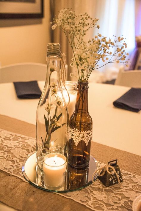 Wine bottle vases sitting atop of a round mirror with votive candle rests on a burlap & lace table runner, complete with a bell to "ring for a kiss." Wine Centerpieces, Wine Decorations, 39 Birthday, Spring Soiree, Wine Bottle Vases, Wine Bottle Centerpieces, Bottle Vases, Wedding Wine Bottles, Table Runner Diy