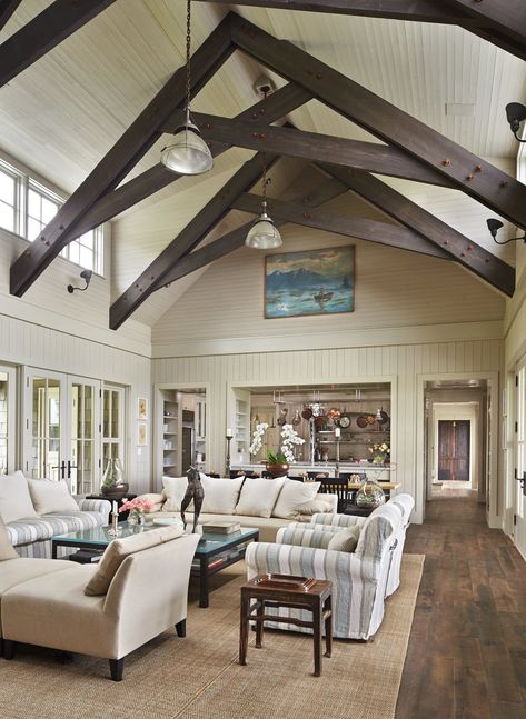 Exposed scissor trusses rise in the great room. The dining table (behind the sofa) was custom-made in France from reclaimed wood, interior designer Rocky Rochon says; the space called for a “really narrow table.” (Benjamin Benschneider / The Seattle Times) Cozy Beach House, Metal Barn Homes, Beach House Interior Design, Whidbey Island, Beach House Interior, Beach House Design, Cozy Farmhouse, Metal Building Homes, Barn House Plans