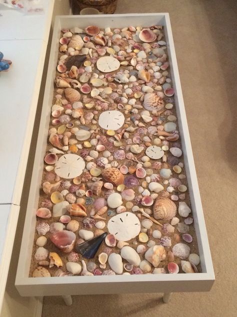 Seashell coffee table - Ugly, old shadow box table that I painted white, added sand, and added seashells I collected in Sanibel, FL (glass not placed here).....Inspired by: https://www.primeriti.es/blog/decoideas/ideas-para-decorar-con-conchas-marinas/ Seashell Coffee Table, Seashell Resin Table, Display Table Ideas, Seashell Table, Shadow Box Table, Shadow Box Coffee Table, Diy Coffee Tables, Seashell Display, Shell Display