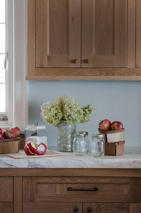 Lovely kitchen features brown cabinets adorned with oil-rubbed bronze hardware topped with white marble alongside blue walls. Brown Kitchen Cabinets, Outdoor Kitchen Countertops, Color Kitchen, Oak Kitchen Cabinets, Brown Kitchens, Kitchen Cabinets Makeover, Oak Kitchen, Diy Holz, Kitchen Marble