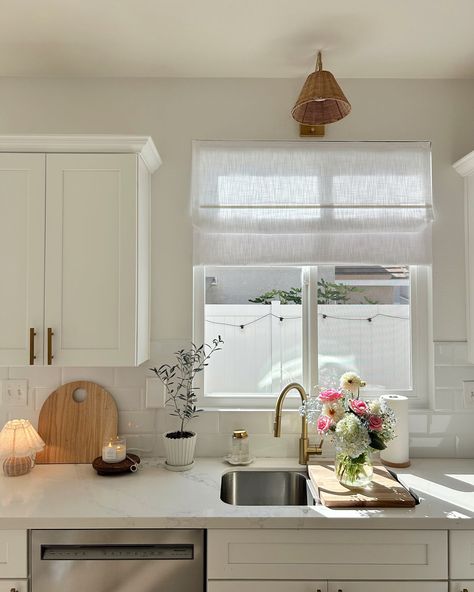 Does it count as an all white kitchen if I add colorful flowers 😅🌸 I do love some light, honey oak kitchen cabinets but for now, white it is down to the new Roman shades 🤩 The new linen shades fit the room and vibe so well my husband didn’t even notice them at first 🤣 The Roman shades & details are linked in my LTK #kitchendecor #affordablehomedecor #easydiy #cleanwithme #diyprojects #neutralhome #whitekitchen #twopageshome Kitchen Window Decor Over Sink, Kitchen Sink Window Treatments, Honey Oak Kitchen Cabinets, Window Above Kitchen Sink, Honey Oak Kitchen, Roman Shades Kitchen, Kitchen Window Decor, Above Kitchen Sink, Window Over Sink