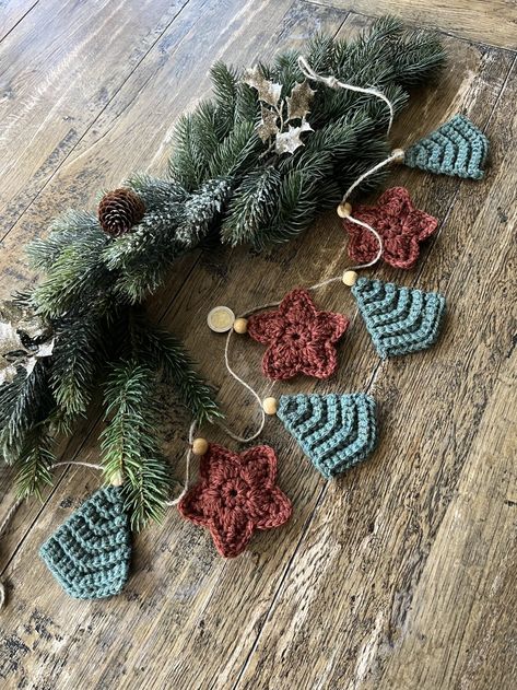 Guirlande de noël fait main au crochet elle créa dans votre intérieur une atmosphère hivernale chaleureuse et très cocooning .elle est en laine elle est composée de 7 éléments 4 sapins et 3 étoilestaille des sapins 9 cm environ, étoiles 8 cm environ chaque élément comporte une perle en boisles boucles aux extrémités sont réglables.les teintes sont beaucoup plus chaude en vrai que sur la photo.je reste à votre disposition si vous avez des questions ou demandes particulières. Noel Diy, Crochet